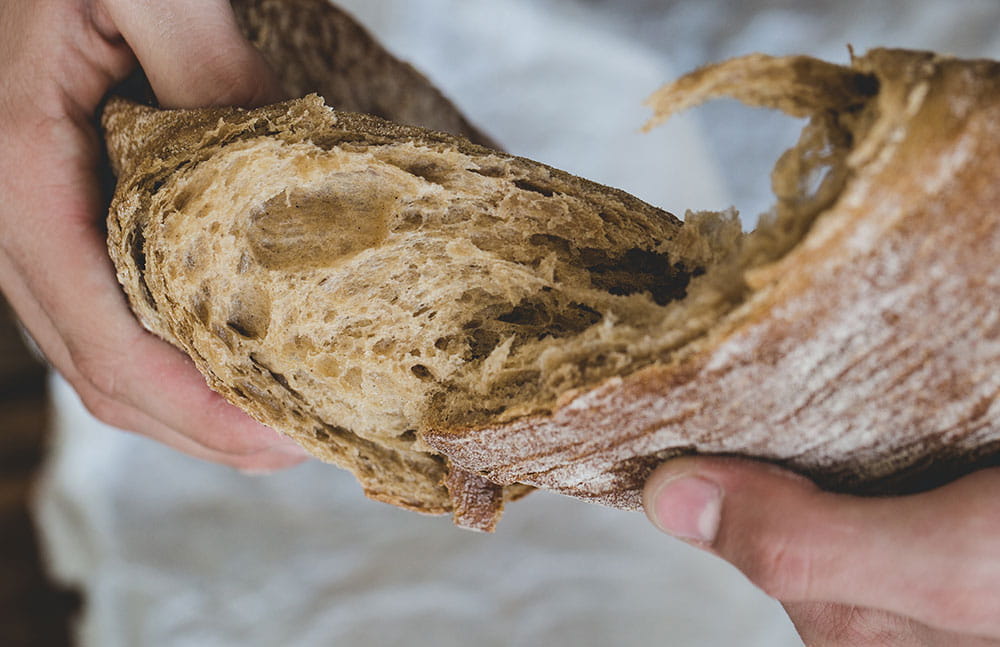 Man tears bread apart